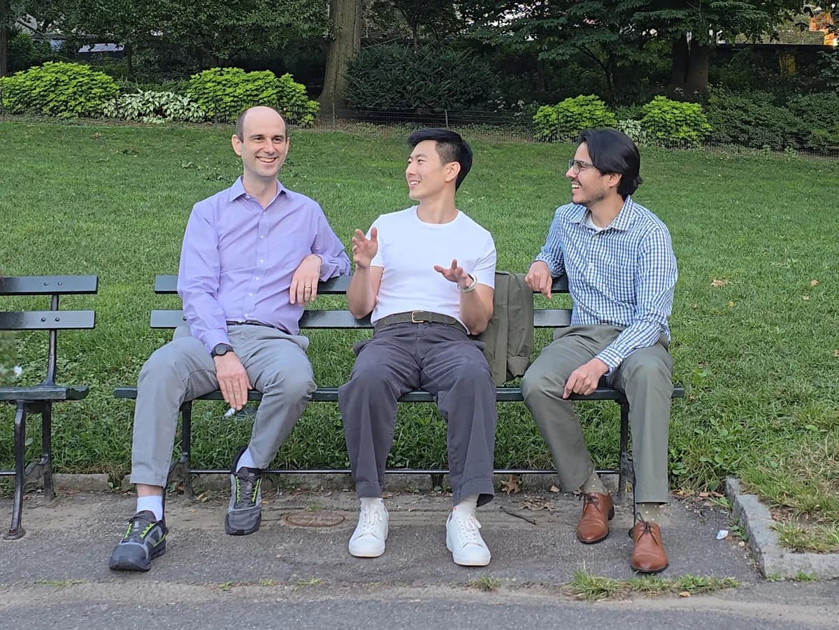 Three Meadow co-founders sitting together on a park bench, in conversation