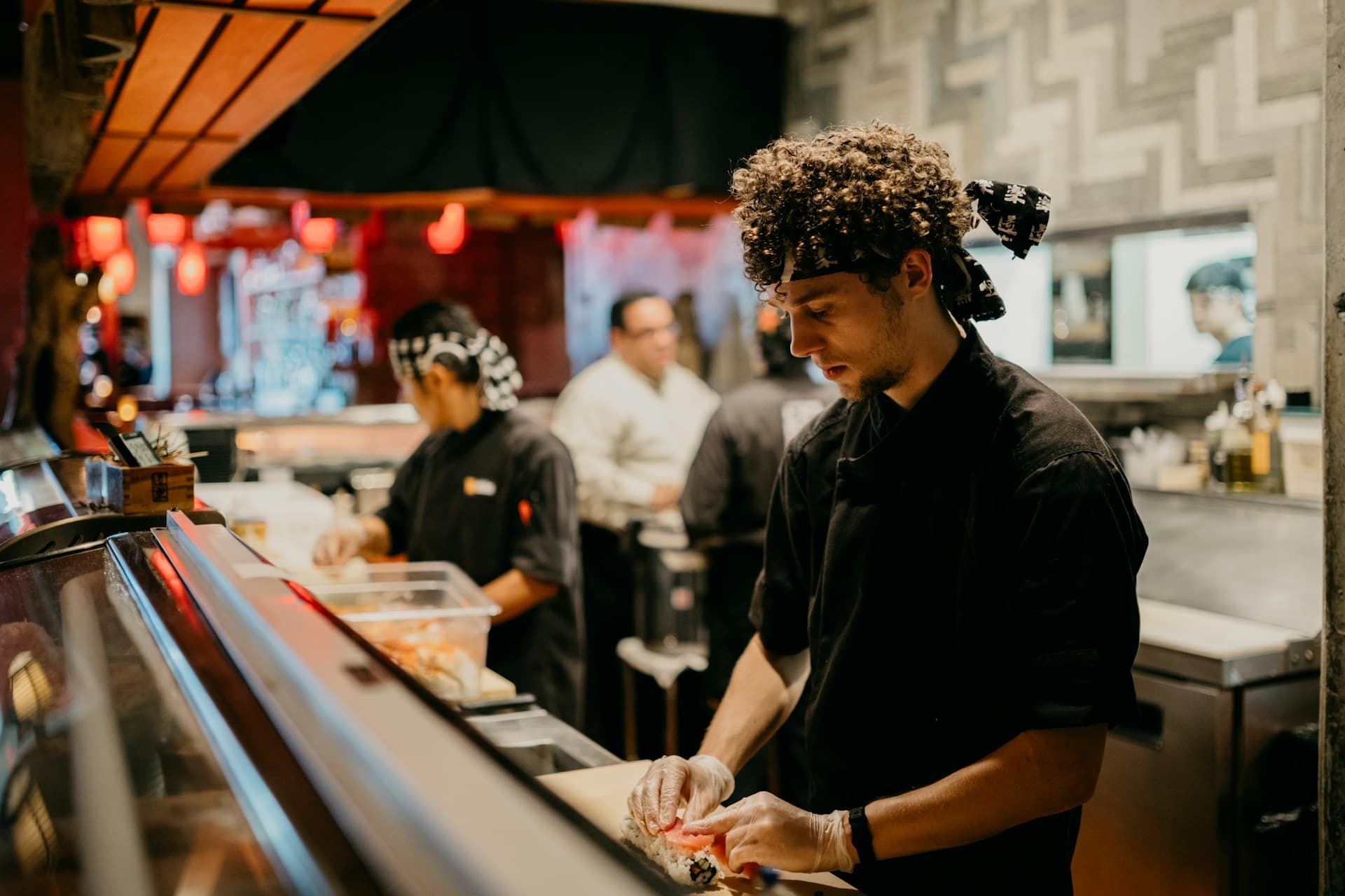 A chef preparing sushi at a restaurant counter
